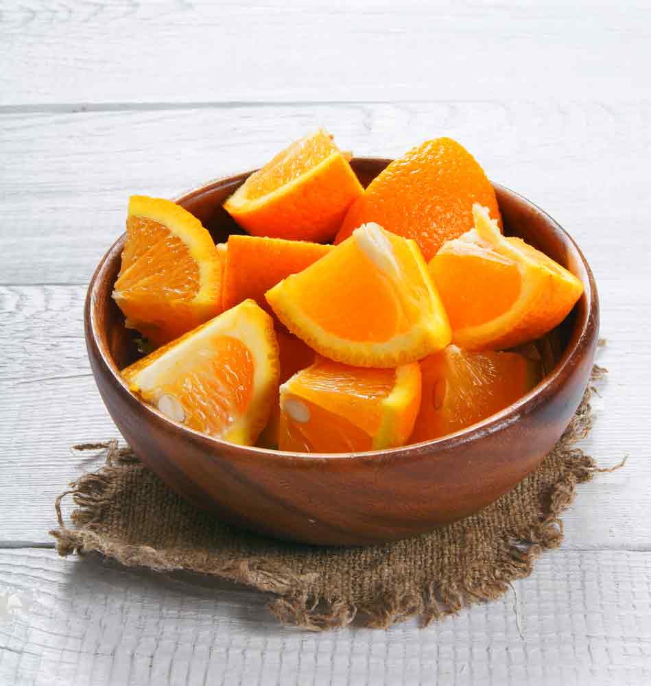 Oragen geschnitten in einer Holzschale
