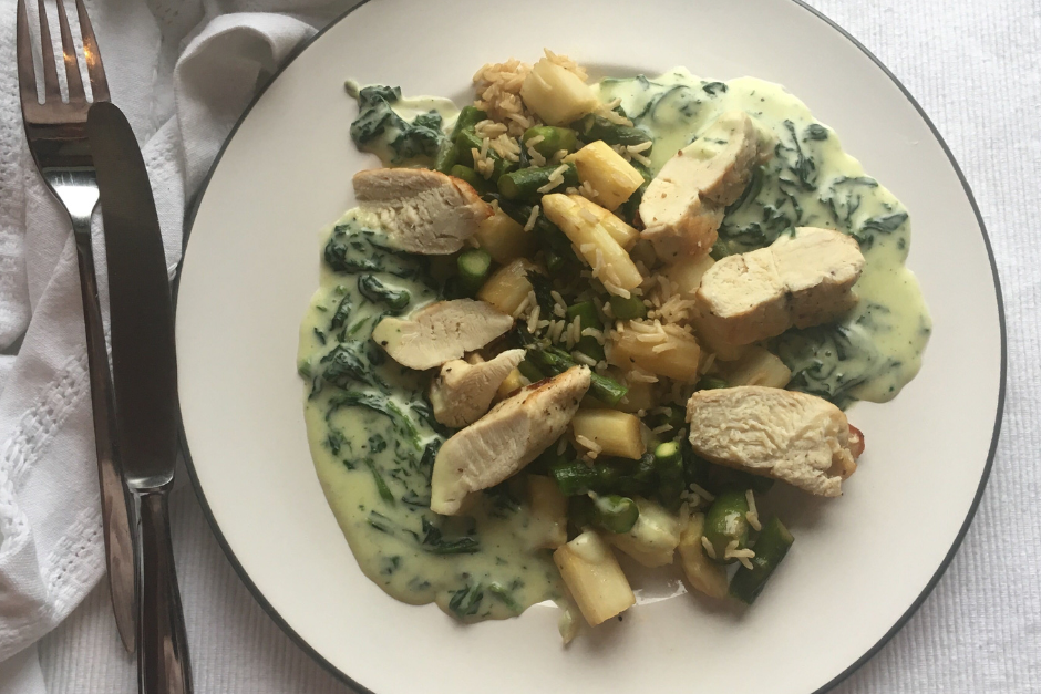 Gebratene Hühnerbrust mit Spargelgemüse und Bärlauchsauce auf einem Teller